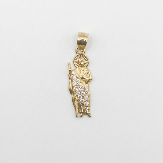 A gold pendant featuring a detailed figure of the Virgin Mary adorned with small clear pavé stones, set against a plain white background.